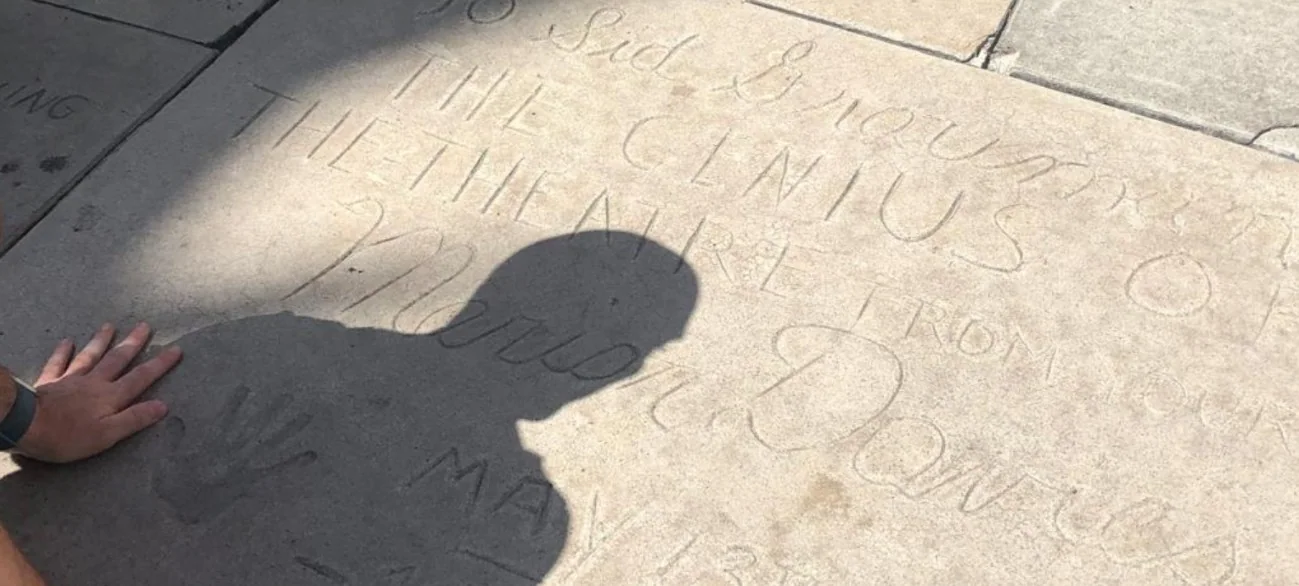A hand beside Marion Davies's handwritten inscription in the Chinese Theatre forecourt